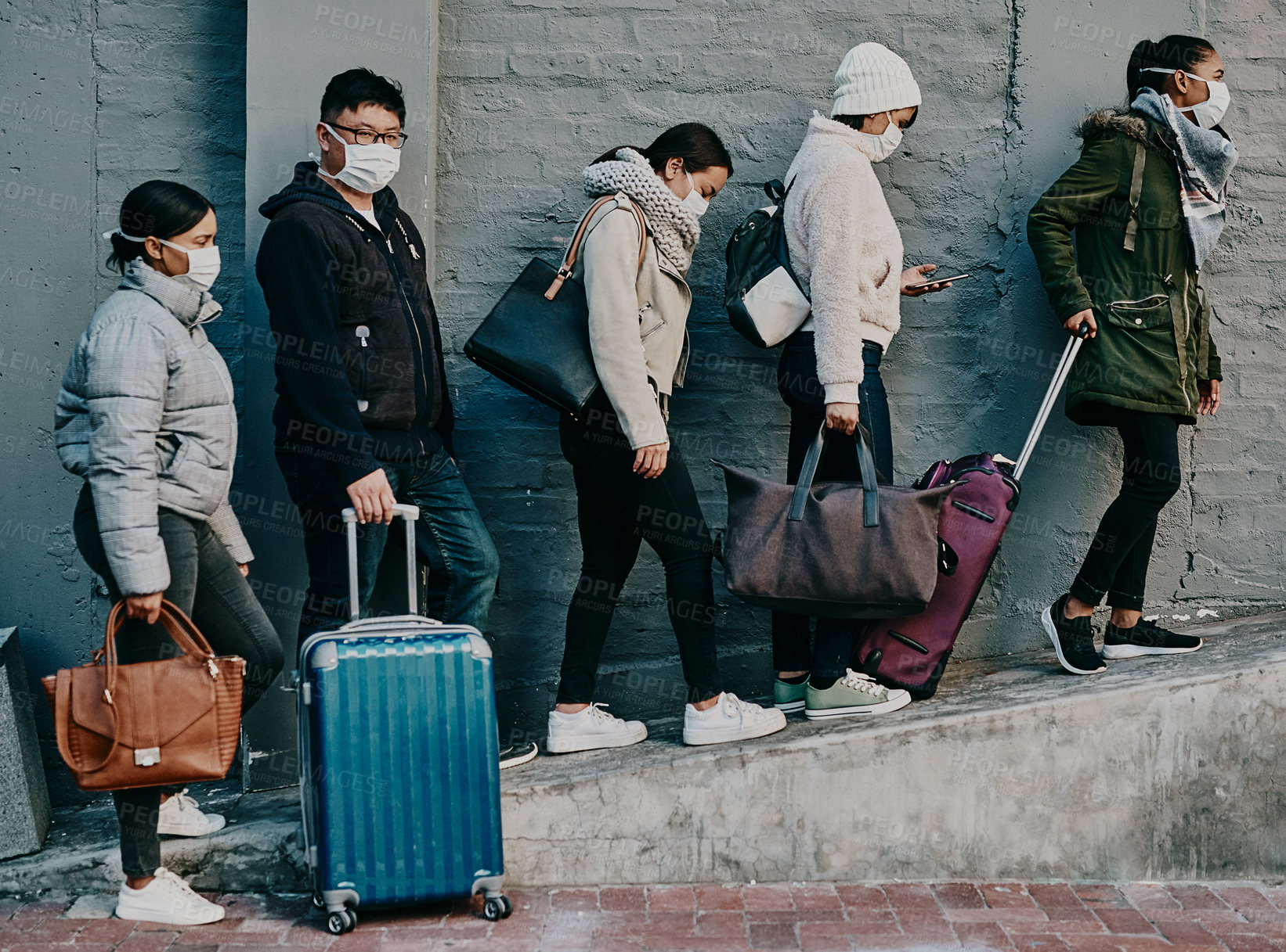 Buy stock photo Traveling people wearing covid face mask and suitcases waiting in line or queue at the airport departure or arrival during a global coronavirus pandemic. Immigration of foreign tourists in quarantine