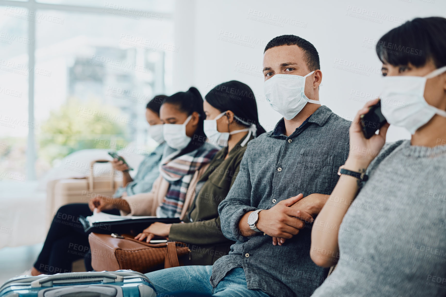 Buy stock photo Shot of a group of young people wearing masks in a waiting room