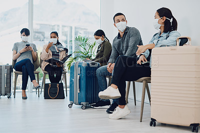 Buy stock photo Group of people traveling during covid waiting in line at an airport lounge wearing protective masks. Tourists sitting in a queue at a public travel facility during coronavirus pandemic