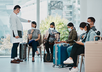 Buy stock photo Covid doctor taking temperature of travel passengers in covid masks during tourism in an airport with an infrared thermometer. Medical professional following safe protocol in an epidemic or outbreak