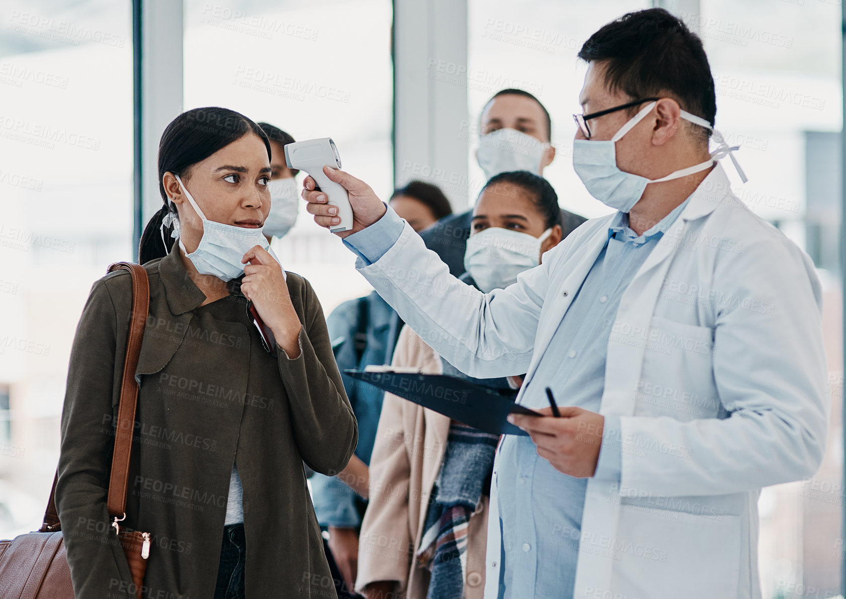 Buy stock photo Travel medical healthcare worker testing covid temperature at airport using infrared thermometer. Professional doctor doing a coronavirus check up on a woman at an office entrance 