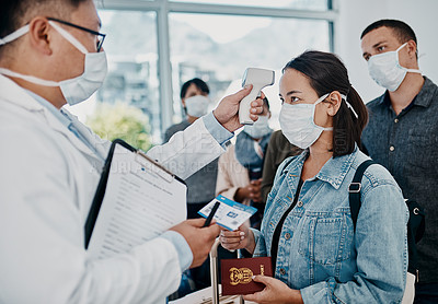 Buy stock photo Travel restriction, covid pandemic and temperature check at airport. Asian female wearing mask for corona virus prevention waiting in departure inspection line, doctor pointing digital thermometer.