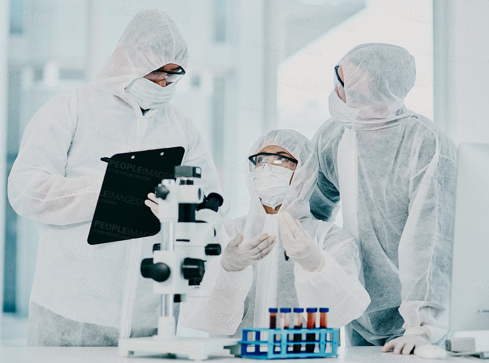 Buy stock photo Science and medical research doctors working on covid vaccine test while wearing protective hazmat suits in modern medicine laboratory. Group of healthcare scientists discussing blood treatment