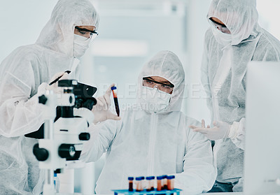Buy stock photo Hazmat suit scientists with test tube in medical research, healthcare or science cure testing for covid, marburg virus or ebola. Group of laboratory professionals looking or checking DNA blood sample
