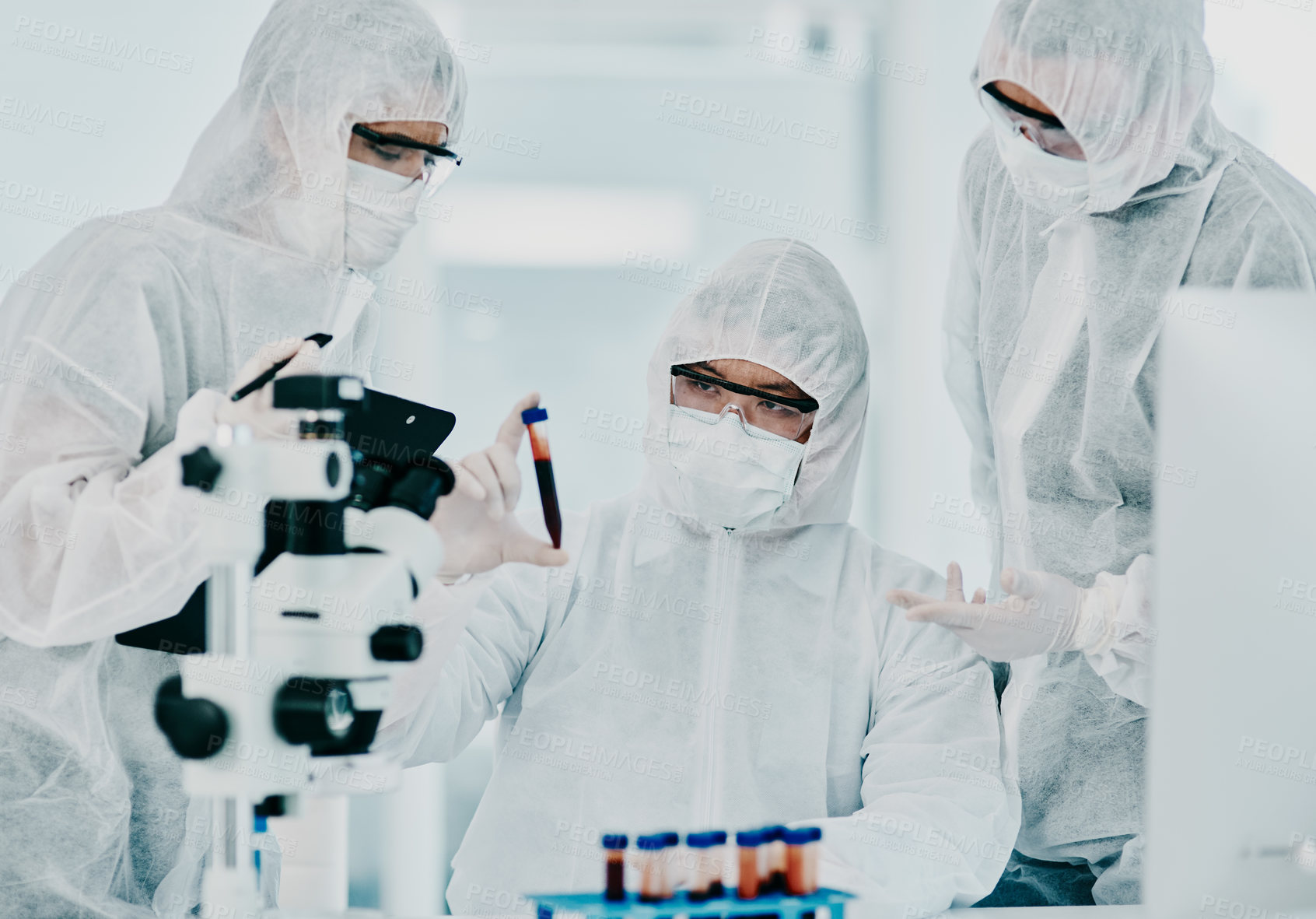 Buy stock photo Hazmat suit scientists with test tube in medical research, healthcare or science cure testing for covid, marburg virus or ebola. Group of laboratory professionals looking or checking DNA blood sample