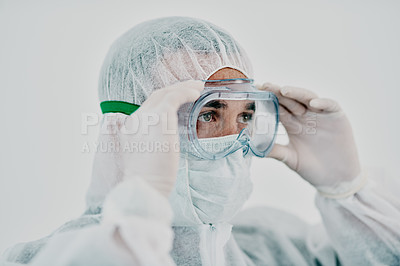 Buy stock photo Healthcare worker wearing protective hazmat suit during covid virus outbreak. Medical research professional in a quarantine zone preparing for sanitizing and staying safe during pandemic restrictions