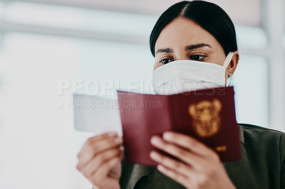 Buy stock photo Shot of a woman wearing a mask and holding her passport in an airport