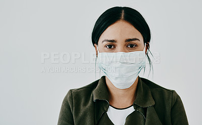 Buy stock photo Portrait of a young woman wearing a mask against a grey studio background