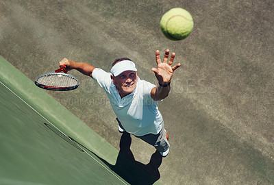 Buy stock photo High angle shot of a focused middle aged man playing tennis while about to serve the ball to his opponent outside during the day