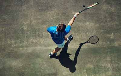 Buy stock photo High angle shot of a focused young man playing tennis outside on a tennis court during the day