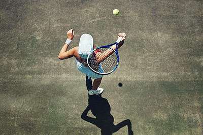 Buy stock photo High angle shot of a focused young woman playing tennis outside on a tennis court during the day
