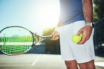 Buy stock photo Cropped shot of an unrecognizable male tennis player holding a tennis ball and racket on a tennis court outdoors