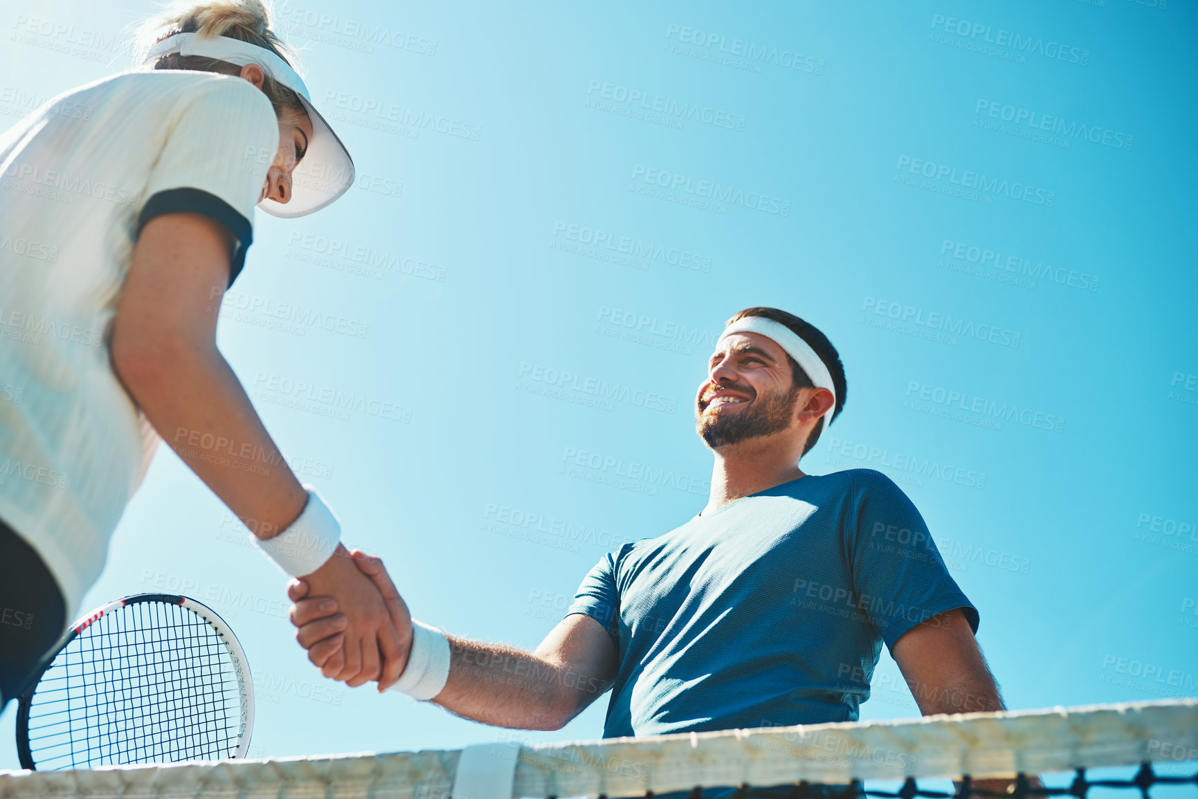 Buy stock photo Cropped shot of two young tennis players shaking hands together outdoors on the court