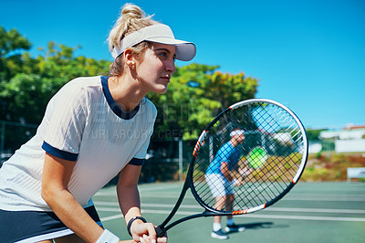 Buy stock photo Cropped shot of an attractive young female tennis player playing together with a male teammate outdoors on a court
