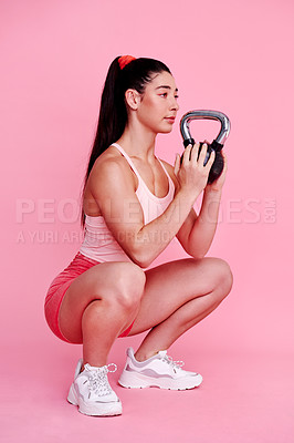 Buy stock photo Fitness, squat and kettlebell with woman in studio for wellness, cardio and challenge. Exercise, workout and training with person on pink background for muscle, performance and sports athlete