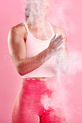 Buy stock photo Studio shot of a sporty young woman dusting her hands with powder against a pink background