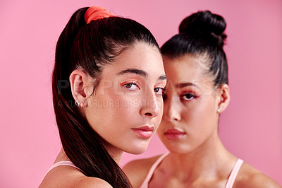 Buy stock photo Studio portrait of two sporty young women standing together against a pink background