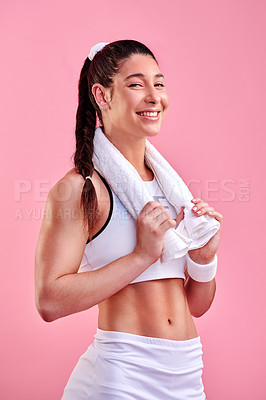 Buy stock photo Studio portrait of a sporty young woman posing with a towel around her neck against a pink background