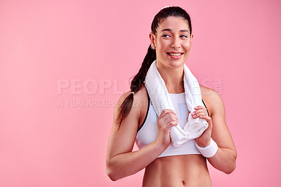 Buy stock photo Studio shot of a sporty young woman posing with a towel around her neck against a pink background