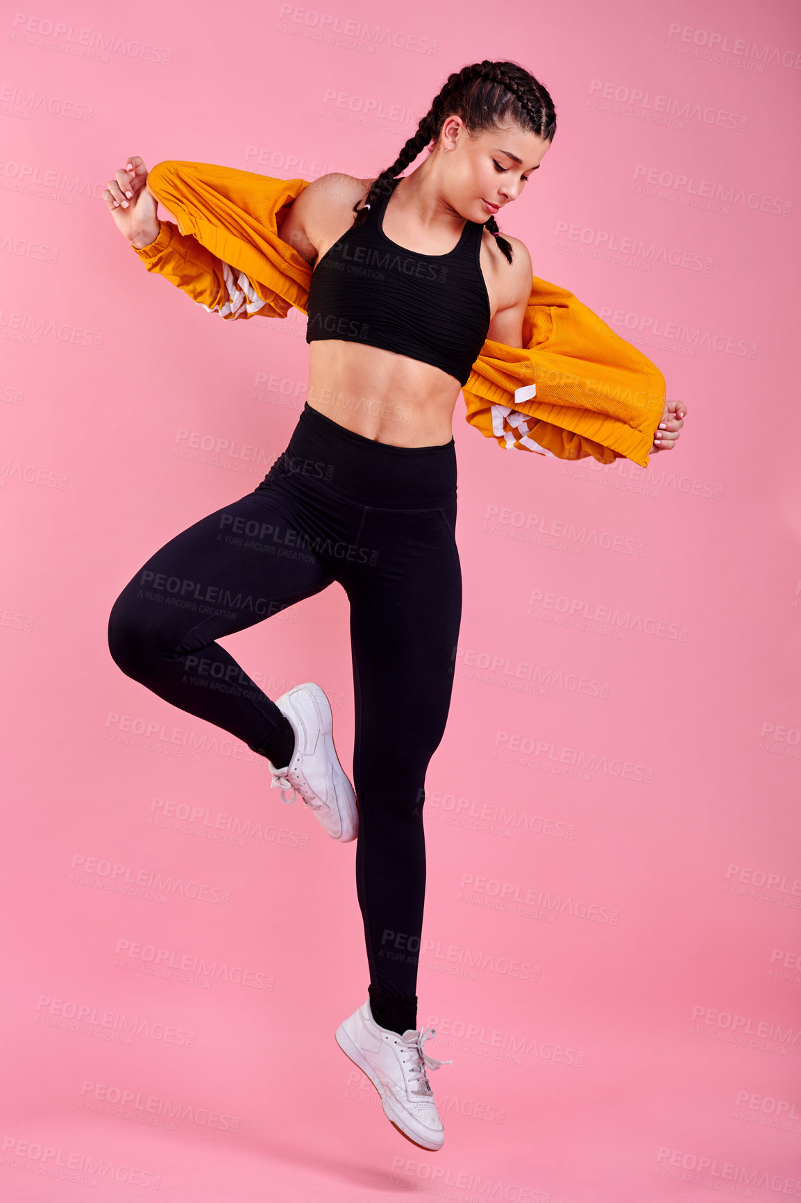 Buy stock photo Fitness, jumping and woman in studio for dancing, cool fashion and exercise challenge. Trendy clothes, creative workout and gen z girl on pink background for training, performance or sports athlete