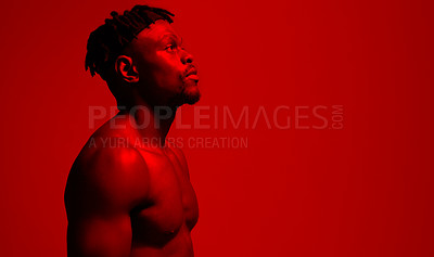 Buy stock photo Red filtered shot of a young sportsman posing in the studio