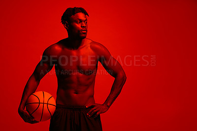 Buy stock photo Red filtered shot of a young sportsman posing with a basketball in the studio