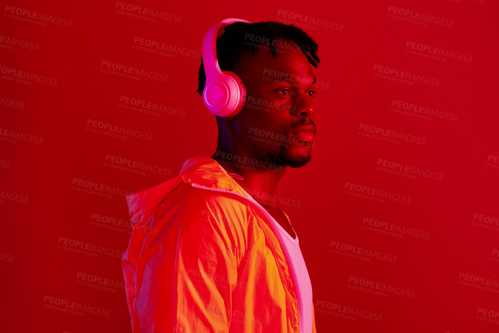 Buy stock photo Headphones, fashion and black man profile with music and online song streaming. Internet radio, web audio and African male model with red background in a studio with gen z style and neon lighting