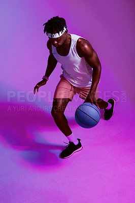 Buy stock photo Purple filtered shot of a sporty young man playing basketball