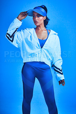 Buy stock photo Cropped shot of an attractive young female athlete posing against a blue background