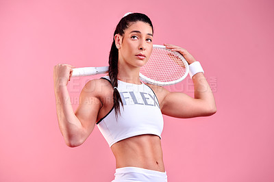 Buy stock photo Studio shot of a sporty young woman holding a tennis racket against a pink background