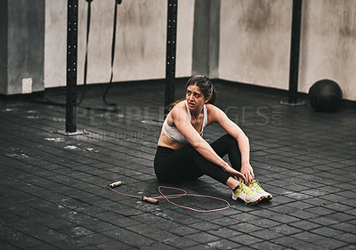 Buy stock photo Shot of a young woman taking a break while working out in a gym