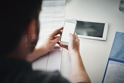 Buy stock photo Shot of an unrecognizable man texting on his cellphone while being seated inside of the office during the day