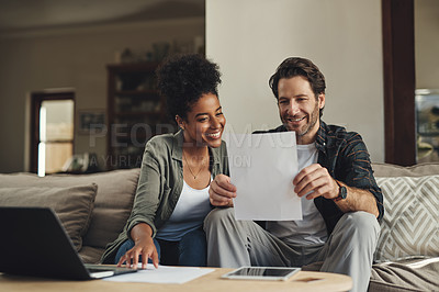 Buy stock photo Shot of a happy young couple going over some paperwork together at home
