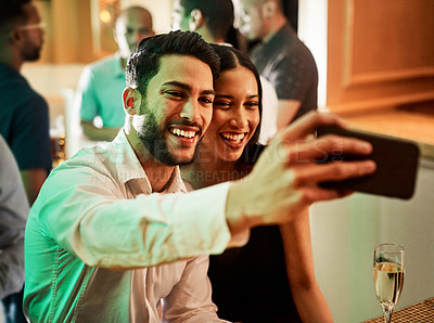 Buy stock photo Cropped shot of two cheerful young friends taking a self portrait together inside of a bar at night