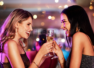 Buy stock photo Cropped shot of two cheerful young women having a celebratory toast with drinks inside of a bar at night