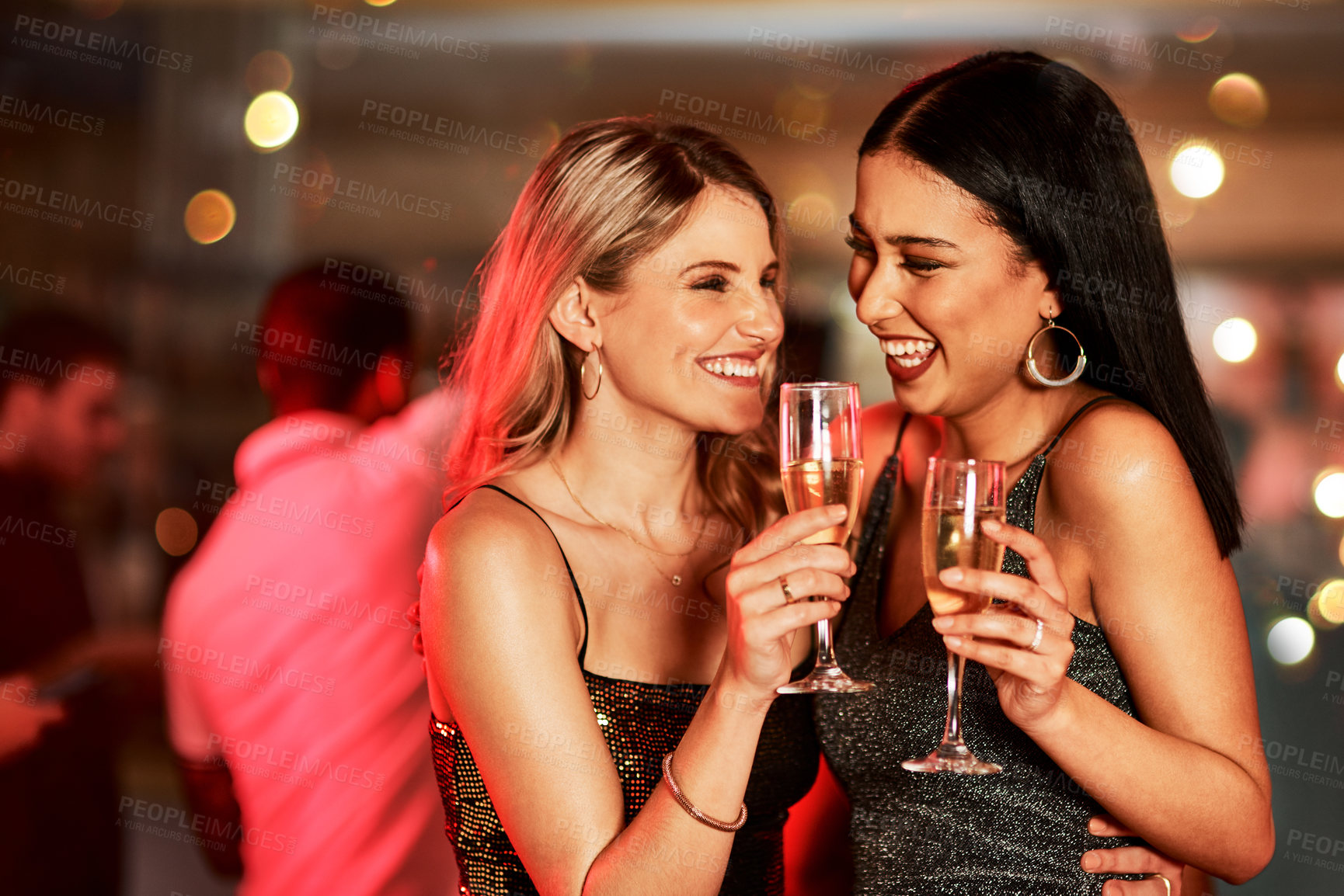 Buy stock photo Cropped shot of two cheerful young women having a celebratory toast with drinks inside of a bar at night