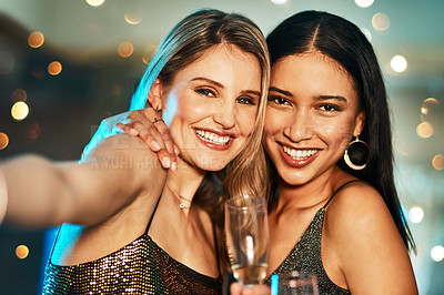 Buy stock photo Portrait of two cheerful young women taking a self portrait together inside of a bar at night
