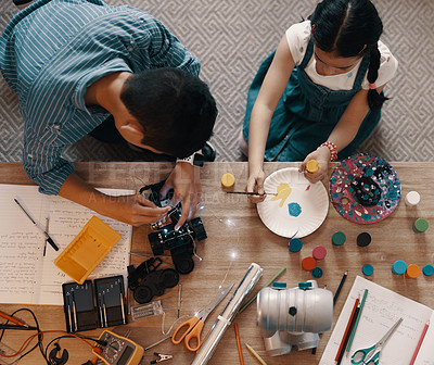 Buy stock photo High angle shot of two young siblings building a robotic toy car together at home