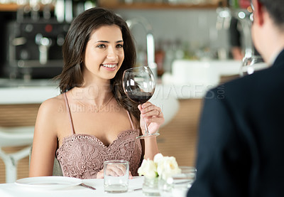 Buy stock photo Shot of a happy young couple enjoying a romantic date at a restaurant