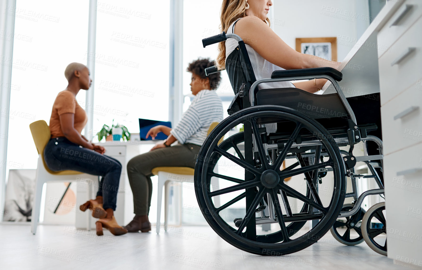Buy stock photo Shot of a woman in a wheelchair working in a coworking space