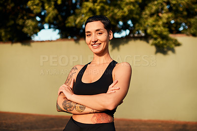 Buy stock photo Cropped shot of an attractive young sportswoman standing alone on the court with her arms folded during the day