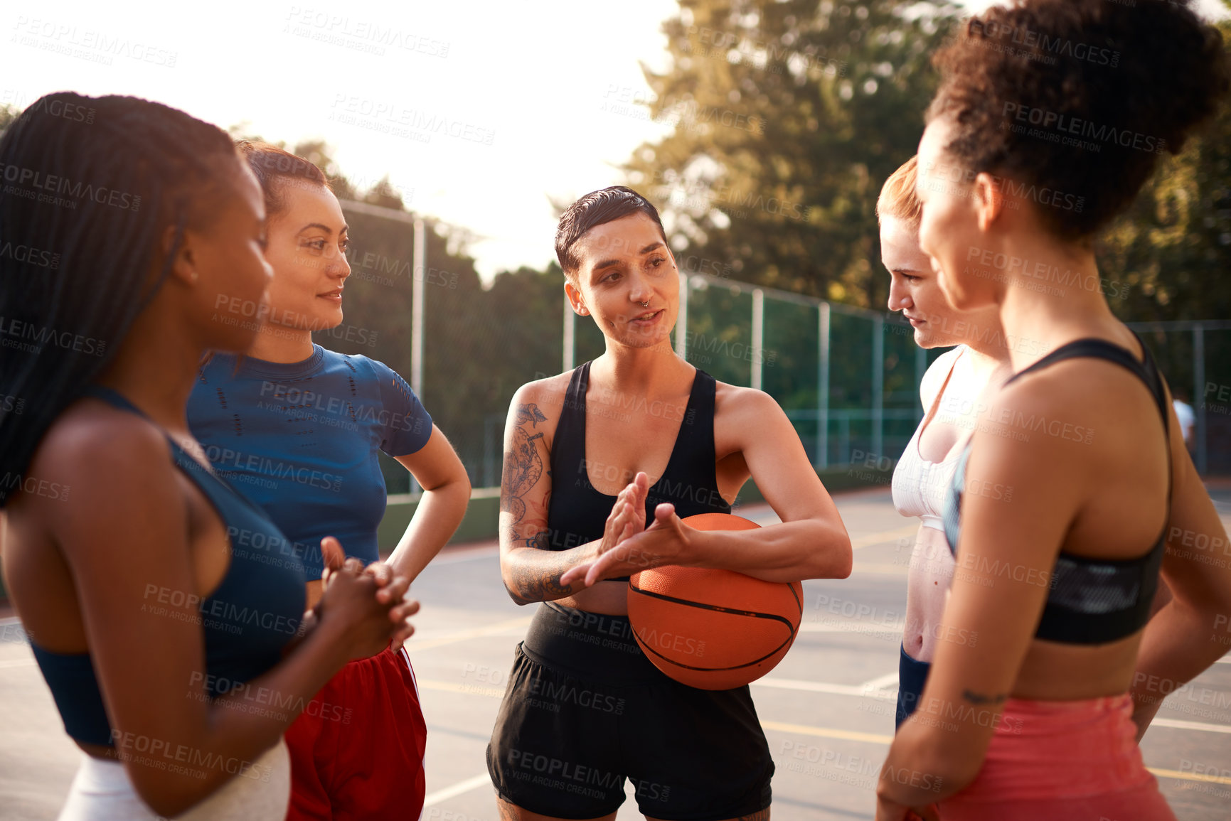 Buy stock photo Cropped shot of a diverse group of friends getting ready to play a game of basketball together during the day