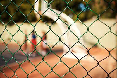 Buy stock photo Fence, basketball court and safety with steel for game, match or blur background of outdoor turf. Closeup, security and boundry with people, team or netting for sport, yard or boundary gate on pitch