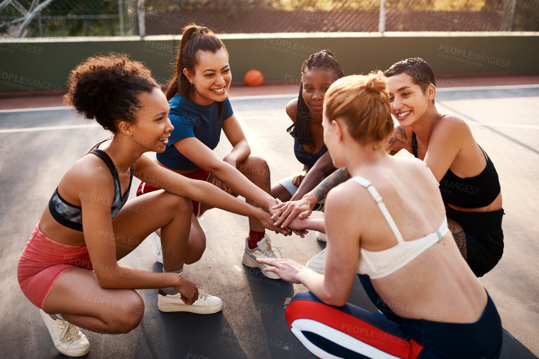 Buy stock photo Cropped shot of a diverse group of sportswomen piling their hands together before playing basketball during the day