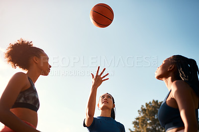 Buy stock photo Cropped shot of a diverse group of sportswomen playing a competitive game of basketball together during the day