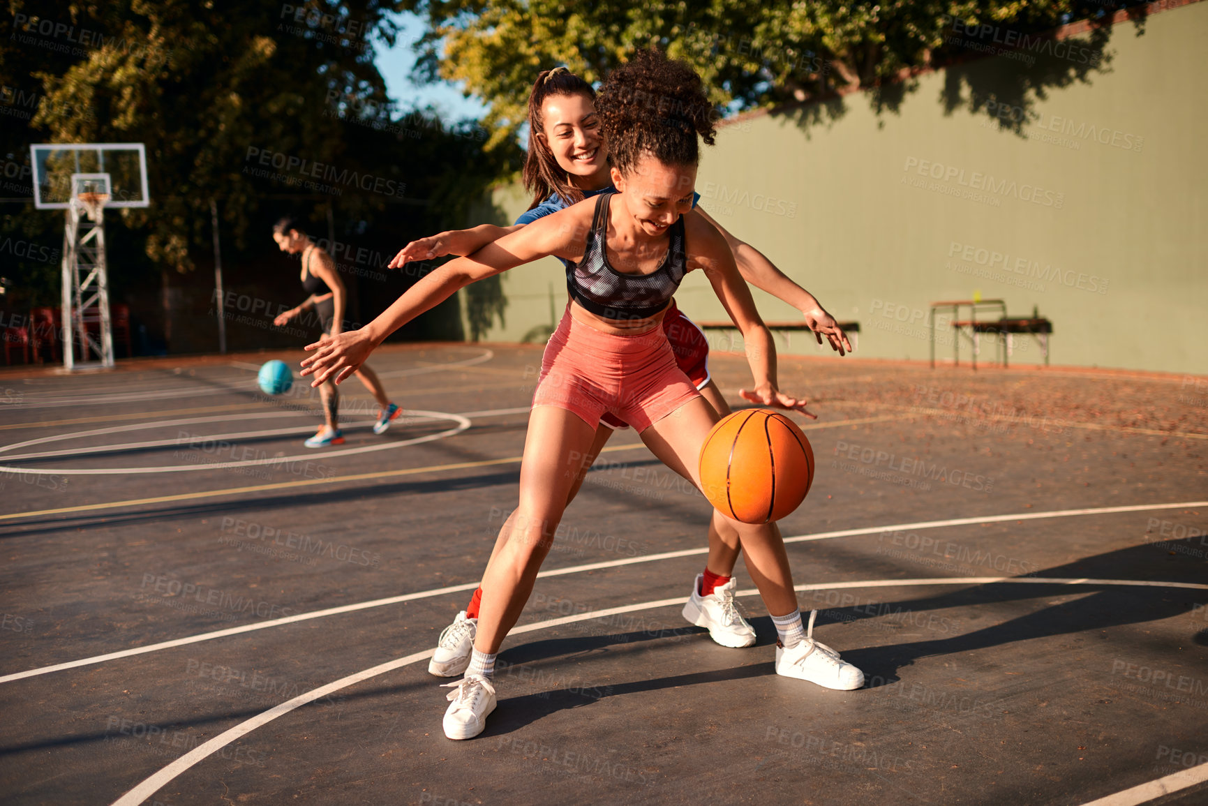 Buy stock photo Cropped shot of an attractive young sportswoman blocking her opponent during a basketball game during the day