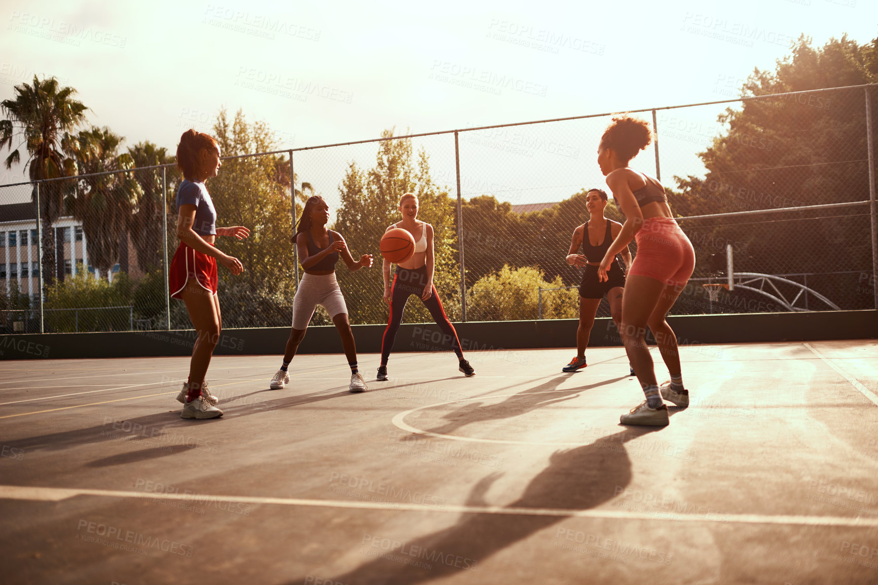 Buy stock photo Cropped shot of a diverse group of sportswomen playing a competitive game of basketball together during the day