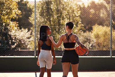 Buy stock photo Cropped shot of two unrecognizable sportswomen bonding after a basketball game together during the day