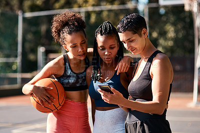 Buy stock photo Basketball, friends and women with phone for sports schedule, social media or show results on chat app. Mobile, ball or group of girls outdoor on break after training, fitness or online game on court