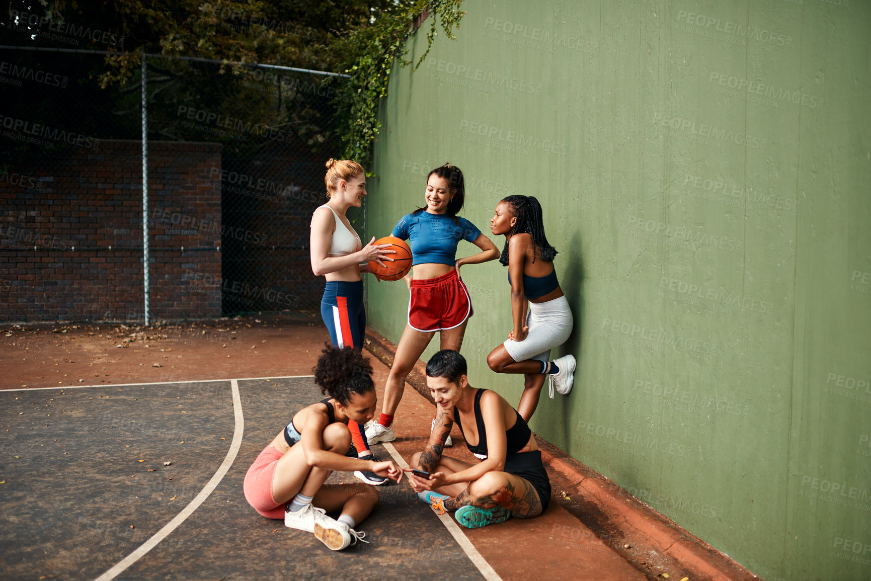 Buy stock photo Cropped shot of a diverse group of sportswomen sitting together for a selfie after a basketball game during the day